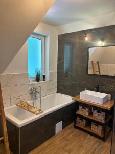 a large bathroom with a tub and a sink at Flow House in Satu Mare