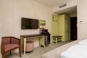 a bedroom with a bed and a desk with a television at Licorna La Vie in Gura Vadului