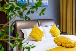 a bed with yellow and white pillows on it at 悦江阁美宿 in Chongqing