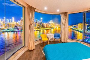 a bedroom with a window with a view of a city at 悦江阁美宿 in Chongqing