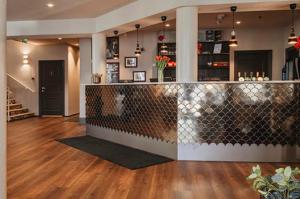 a restaurant with a bar in a room with wood floors at Home Hotel Amanda in Haugesund