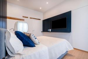 a bedroom with a bed with a tv on the wall at Infinito Luxury by BarbarHouse in Monopoli