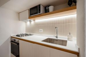 a kitchen with a sink and a microwave at Infinito Luxury by BarbarHouse in Monopoli +79 photos
