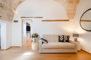 a living room with a couch and a mirror at Infinito Luxury by BarbarHouse in Monopoli
