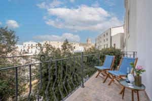a balcony with two chairs and a view of the city at Infinito Luxury by BarbarHouse in Monopoli