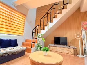 a living room with a couch and a tv at Santiago City Transient House in Santiago