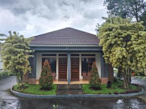 a small house with two christmas trees in front of it at INDO ALAM RECREATIONAL RESORT in Sindanglaya