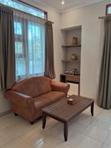 a living room with a brown couch and a coffee table at INDO ALAM RECREATIONAL RESORT in Sindanglaya