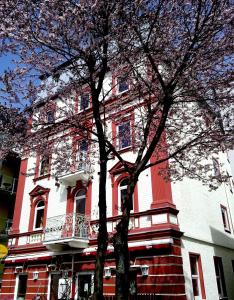 ein rot-weißes Gebäude mit einem Baum davor in der Unterkunft Hotel Traube in Zell am See
