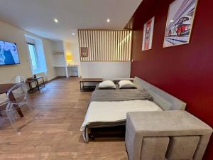 a living room with two beds and a table at Le Martini in Chalon-sur-Saône