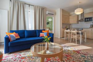 a living room with a blue couch and a table at GreenVista 20 minutes by Therme & Airport in Voluntari