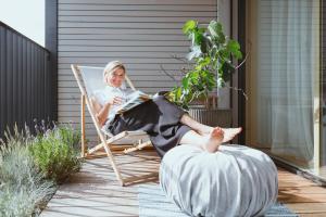 a woman sitting in a chair on a porch with her feet up at Coho Slowliving in Linz