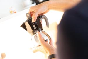 a person holding a coffee cup in their hand at Coho Slowliving in Linz