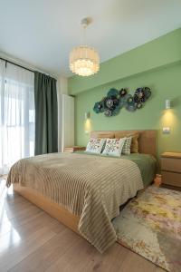 a bedroom with a large bed and a chandelier at GreenVista 20 minutes by Therme & Airport in Voluntari