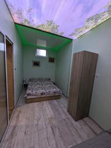 a room with a bed and a ceiling with a window at Наслада in Panagyurishte