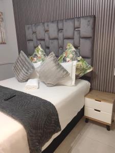a bedroom with a bed with a headboard and pillows at The Rehoboth in Dundee
