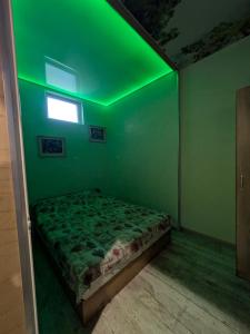 a green room with a bed with a green ceiling at Наслада in Panagyurishte +4 photos