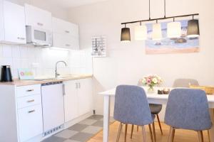a kitchen with a table and two blue chairs at Appartementhaus Sonnenschein - 250m zum Strand im Zentrum von Binz in Binz