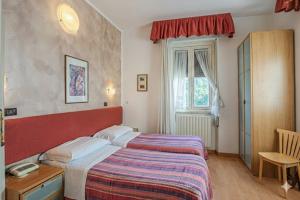 a hotel room with two beds and a window at Hotel Paradiso in Monteluco