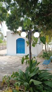 a blue door on a white building with a tree at Kite House Barreiras in Macau