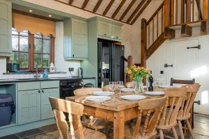 a kitchen with a wooden table and some chairs at Coach House in Pembroke