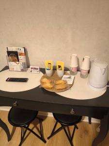 a table with a tray of donuts and cups on it at Les Bergeronnettes in Trénal