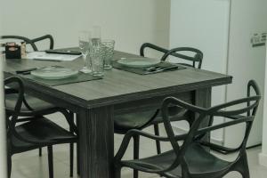a wooden table with chairs and plates and glasses on it at Adriatica Apartamentos in San Luis +43 photos