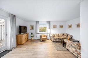 a living room with a couch and a tv at Feriehus Oluf in Ålbæk