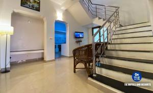 a staircase in a room with a chair and a television at Townhouse 4bhk Bungalow - TIE Hotels in Pondicherry