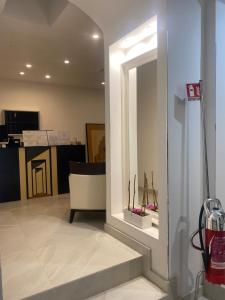 a hallway with a mirror and a chair in a room at Hotel Plebiscito Aparthotel in Naples