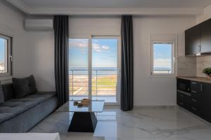 a living room with a couch and a view of the ocean at Delfini Girni Apartments in Paralia Katerinis