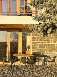 a table and chairs in front of a building at Lombtér in Pásztó