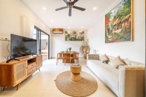 a living room with a couch and a tv at Cassandra Villas - Tropical Private Pool Escape near Beach in Sanur
