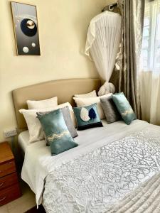 a bedroom with a bed with pillows on it at Peaceful Place 1 in Nairobi