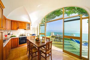 a kitchen with a table and a view of the ocean at House Teresa - private pool in Praiano