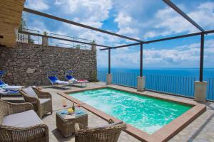 a swimming pool on a patio with a view of the ocean at House Teresa - private pool in Praiano