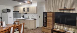 a kitchen with a large flat screen tv and a table at Pension u Veverků in Protivanov