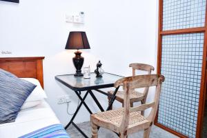 a bedroom with a table and a chair next to a bed at ELOP Resturant & Villa in Piyadigama