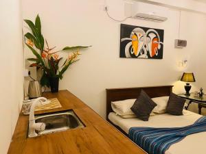 a room with two beds and a desk with a telephone at ELOP Resturant & Villa in Piyadigama +59 photos
