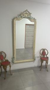 a mirror sitting on a wall with two chairs and a mirror at Adriatica Apartamentos in San Luis