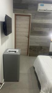 a bedroom with a bed and a television and a door at Adriatica Apartamentos in San Luis