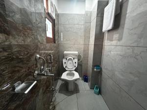 a bathroom with a toilet and a shower at Uttarayan The Homestay in Almora