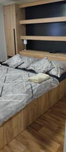 a bed with a wooden headboard with a pillow on it at Pension u Veverků in Protivanov