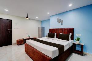 a bedroom with a large bed and a blue wall at Hotel O Khusi Tranquil Domicile in Bhubaneshwar