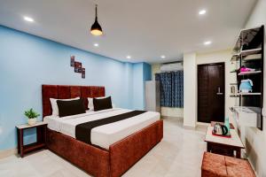 a bedroom with a bed and a blue wall at Hotel O Khusi Tranquil Domicile in Bhubaneshwar +21 photos