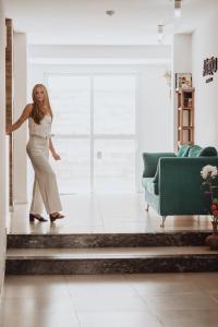 a woman is standing in a living room at Adriatica Apartamentos in San Luis