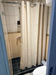 a shower with a shower curtain in a bathroom at Ivory & Rose Studio in Tartu