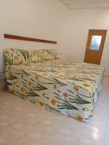 a bed with a floral comforter in a bedroom at Zendora Resort Yala in Tissamaharama