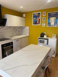 a kitchen with a large white counter top at La Grange des Pépettes ! in Saint-Germain-des-Fossés