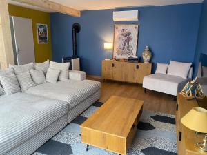 a living room with a couch and a table at La Grange des Pépettes ! in Saint-Germain-des-Fossés